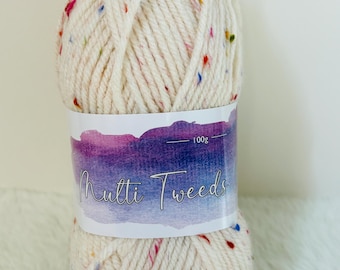 Puede incluir: Una bola de hilo de color crema con motas multicolores. El hilo está etiquetado como "Multi Tweeds" y "100g".