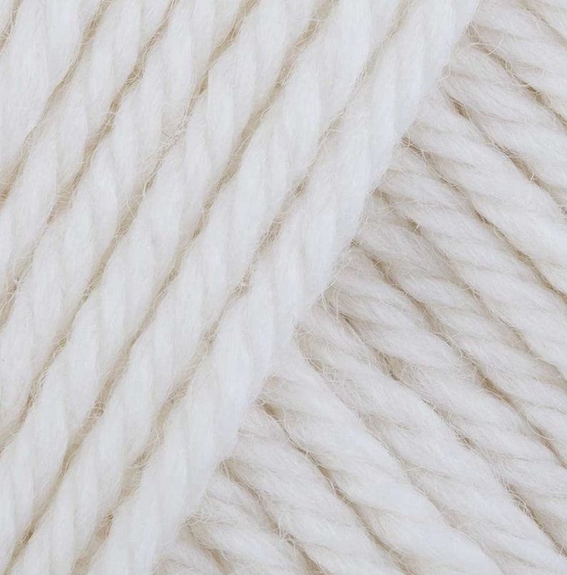 May include: Close-up of a white yarn skein. The yarn is soft and fluffy, with a slightly textured surface.