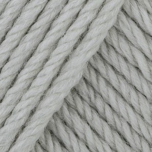 May include: Close-up of a skein of light gray yarn. The yarn is made of a soft, fluffy fiber and has a slightly textured surface.