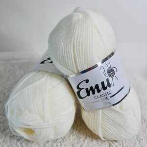 May include: Two balls of white Emu Classic DK yarn, each with a label that says "Emu Classic DK 100g".