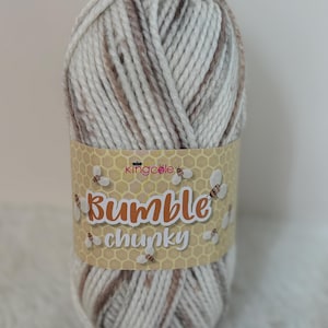 May include: A ball of white and brown chunky yarn with a label that says "Bumble Chunky" and a bee logo.