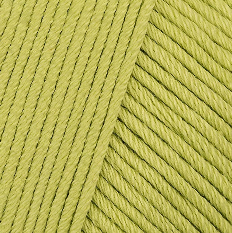 May include: Close-up of a skein of light green yarn. The yarn is soft and fluffy, and it has a subtle sheen.
