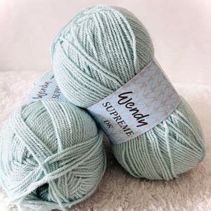 May include: Two skeins of light blue yarn labeled "Wendy Supreme DK".