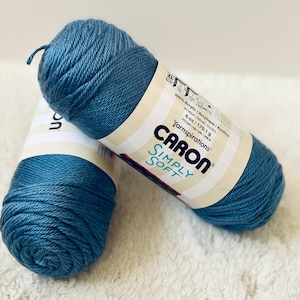 Pode incluir: Dois novelos de fio Caron Simply Soft na cor azul-verde. O fio é 100% acrílico e vem em um novelo de 170,1 gramas com 288 metros de fio.