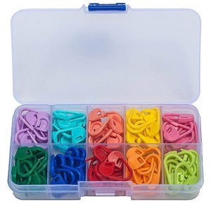 Könnte beinhalten: Eine transparente Plastik-Aufbewahrungsbox mit blauem Deckel, die eine Vielzahl von bunten Plastik-Maschenmarkierern enthält. Die Markierer sind nach Farbe in Reihen sortiert, darunter lila, türkis, orange, gelb, rosa, grün, blau und rot.