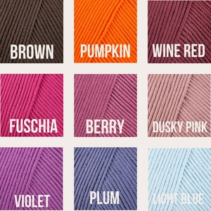 May include: A color chart of yarn samples in various shades of brown, orange, red, pink, purple, and blue. The yarn samples are labeled with the following names: Brown, Pumpkin, Wine Red, Fuschia, Berry, Dusky Pink, Violet, Plum, and Light Blue.