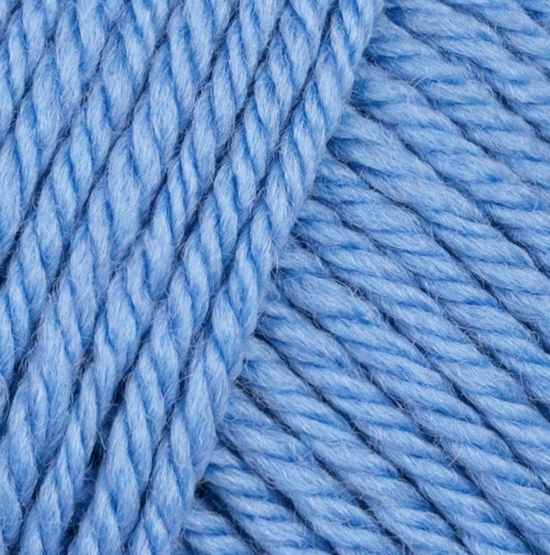 May include: Close-up of a skein of light blue yarn. The yarn is soft and fluffy, and it is perfect for knitting or crocheting.