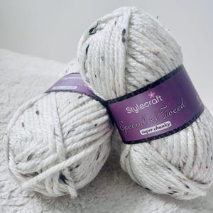 Peut inclure: Deux pelotes de fil blanc avec des points noirs. Le fil est &eacute;tiquet&eacute; "Stylecraft Special XL Tweed super chunky."