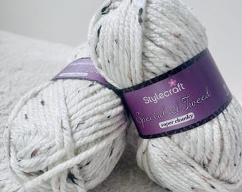 May include: Two balls of white yarn with black flecks. The yarn is labeled "Stylecraft Special XL Tweed super chunky."