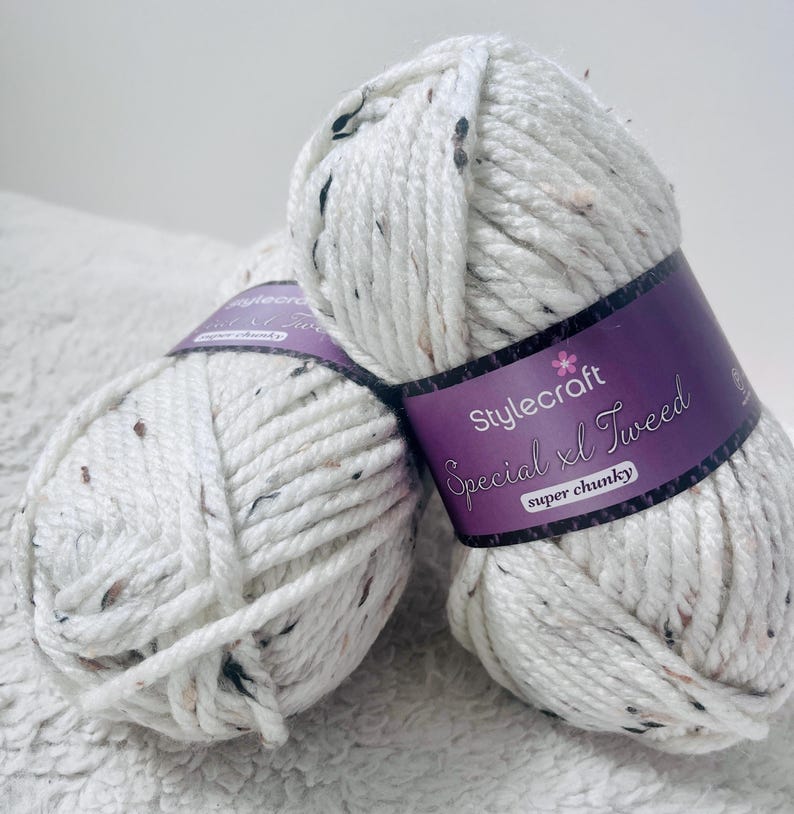 Peut inclure: Deux pelotes de fil blanc avec des points noirs. Le fil est &eacute;tiquet&eacute; "Stylecraft Special XL Tweed super chunky."