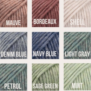 May include: Nine yarn skeins in different colors, including mauve, bordeaux, shell, denim blue, navy blue, light gray, petrol, sage green, and mint.
