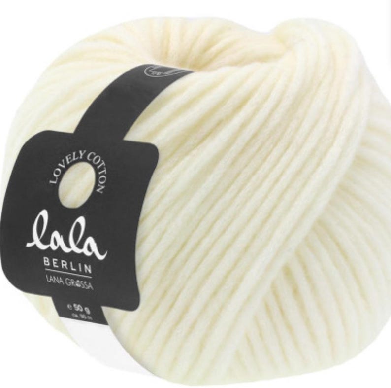 May include: A ball of off-white yarn with a black label that says "lala BERLIN LANA GROSSA e 50 g"