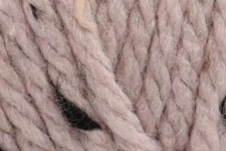 Peut inclure: Gros plan d'une pelote de fil doux et &eacute;pais de couleur rose poudr&eacute;. Le fil a une texture l&eacute;g&egrave;rement duveteuse.