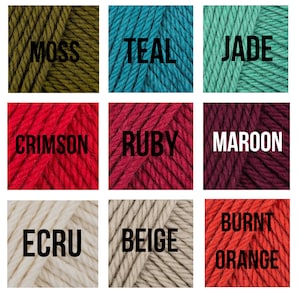 May include: Nine yarn skeins in various colors, including moss green, teal, jade, crimson, ruby, maroon, ecru, beige, and burnt orange.