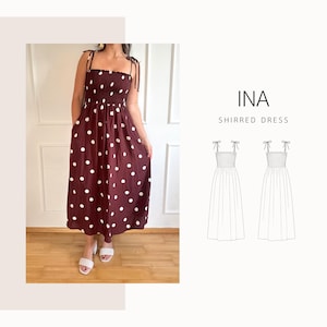 May include: A burgundy shirred dress with white polka dots. The dress features a smocked bodice, tie straps, and a flowing skirt. The image also includes a line drawing of the dress and the text "INA SHIRRED DRESS".