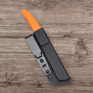 Könnte beinhalten: Ein Messer mit orangefarbenem Griff in einer schwarzen Scheide mit Gürtelclip. Das Messer ist angewinkelt und zeigt den leuchtend orangefarbenen Griff vor der schwarzen Scheide. Die Scheide hat einen Clip zur Befestigung an einem Gürtel oder anderer Ausrüstung.