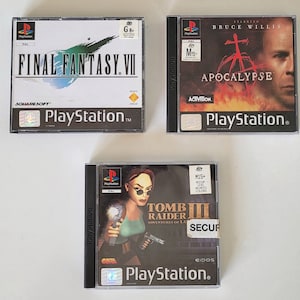 以下が含まれることがあります： PlayStationのビデオゲームケースが3つ。最初のケースは青と白で、「FINAL FANTASY.VII」という文字と「G8+」の評価が書かれている。2番目のケースは赤と黒で、「APOCALYPSE」という文字と「M15-」の評価が書かれている。3番目のケースは黒と緑で、「TOMB RAIDER III」という文字と「M15」の評価が書かれている。