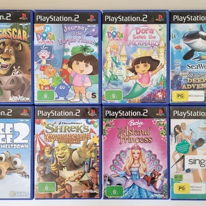 May include: A collection of eight PlayStation 2 video game cases featuring popular children's movie characters, including Madagascar, Dora the Explorer, Shrek, Ice Age, and Barbie. The cases are arranged in two rows of four, with the titles and characters clearly visible.