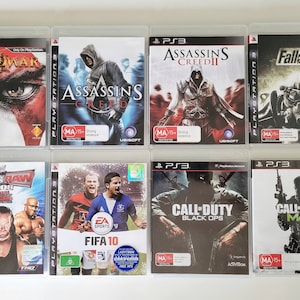 May include: A collection of ten PlayStation 3 video game cases. The games include God of War II, Assassin's Creed, Assassin's Creed II, Fallout 3, SmackDown vs. Raw 2008, FIFA 10, Call of Duty: Black Ops, and Call of Duty: MW3.