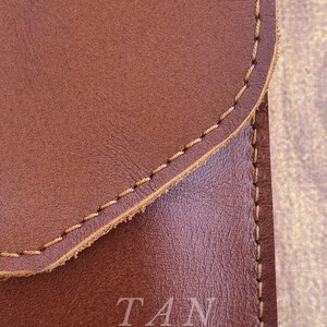 May include: Close-up of a brown leather surface with tan stitching. The text "TAN COLOR" is printed in white on the leather.
