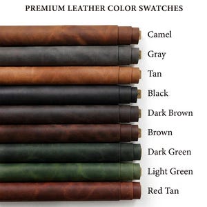 A collection of rolled leather sheets in various colors, including red tan, light green, dark green, brown, dark brown, black, tan, gray, and camel. The colors are labeled with text. The leather appears to be of high quality.