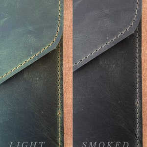 May include: Close-up of two leather pieces, one in a light green color and the other in a dark, almost black color. The text "LIGHT GREEN" is below the light green piece and the text "SMOKED COLOR" is below the dark piece.