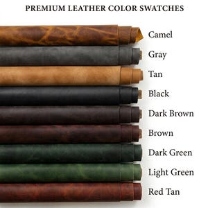 A collection of rolled leather sheets in various colors, including red tan, light green, dark green, brown, dark brown, black, tan, gray, and camel. The colors are labeled with text. The leather appears to be of high quality.