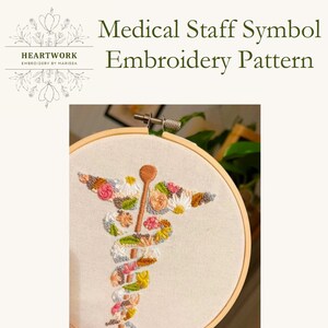 Puede incluir: Patr&oacute;n de bordado del s&iacute;mbolo del personal m&eacute;dico con fondo blanco y aro de madera. El s&iacute;mbolo est&aacute; hecho de flores y hojas coloridas.
