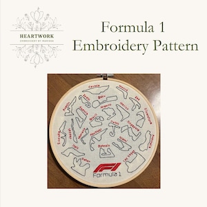 May include: Embroidered Formula 1 race track pattern on a white hoop. The tracks are outlined in black thread and the names of the tracks are written in black thread. The Formula 1 logo is embroidered in red thread in the center of the hoop.