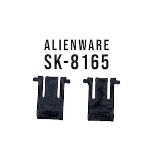 May include: Two black plastic pieces with a series of small holes. The text "Alienware SK-8165" is printed above the pieces.