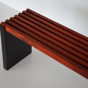 Stylish slatted bench from scorched oak and padauk