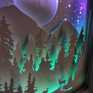 Deer in the Forest Shadow Box SVG design template of a couple walking in the forest with the mountains in the background, can be cut with Cricut, Silhouette Cameo, Brother machines or by hand, designed by The Shadow Box Club