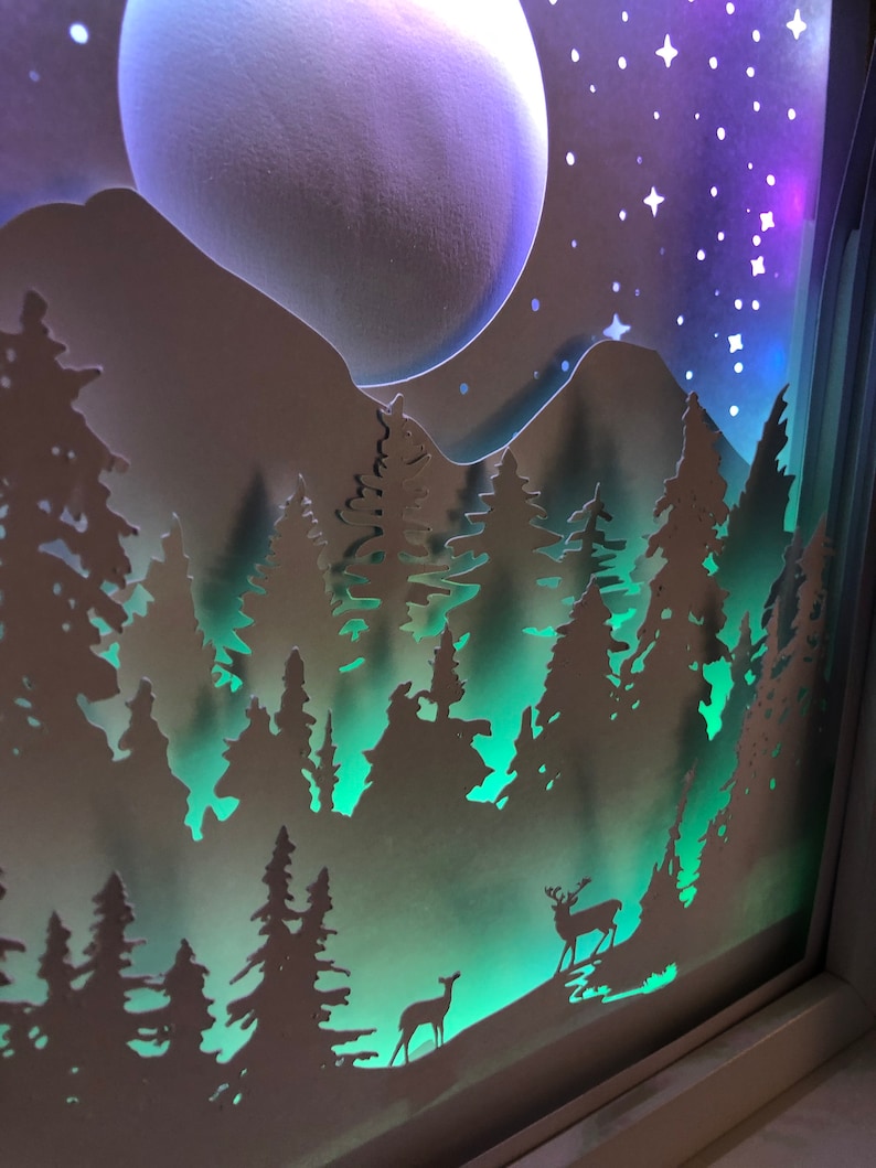 Deer in the Forest Shadow Box SVG design template of a couple walking in the forest with the mountains in the background, can be cut with Cricut, Silhouette Cameo, Brother machines or by hand, designed by The Shadow Box Club