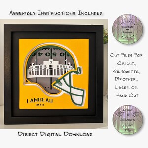 May include: A framed paper craft depicting a yellow American football helmet design with green and white details. The artwork includes a stadium scene and the text "LAMBEAU FIELD." The frame is black, and the image includes the text "ASSEMBLY INSTRUCTIONS INCLUDED" and "DIRECT DIGITAL DOWNLOAD."