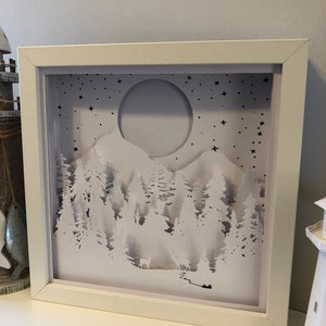 Deer in the Forest Shadow Box SVG design template of a couple walking in the forest with the mountains in the background, can be cut with Cricut, Silhouette Cameo, Brother machines or by hand, designed by The Shadow Box Club