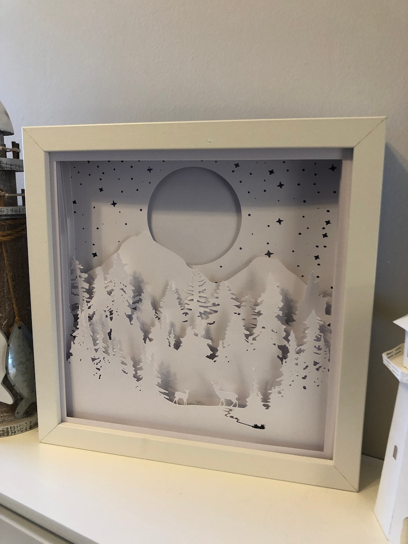 Deer in the Forest Shadow Box SVG design template of a couple walking in the forest with the mountains in the background, can be cut with Cricut, Silhouette Cameo, Brother machines or by hand, designed by The Shadow Box Club
