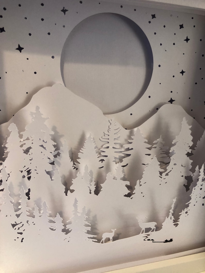 Deer in the Forest Shadow Box SVG design template of a couple walking in the forest with the mountains in the background, can be cut with Cricut, Silhouette Cameo, Brother machines or by hand, designed by The Shadow Box Club
