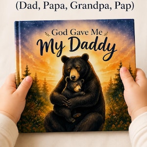 May include: A children's book cover with the text "God Gave Me My Daddy" and an illustration of a bear hugging a cub. The book is held by a person. The top of the image has the text "Personalize with the name of the father figure in your life (Dad, Papa, Grandpa, Pap)".