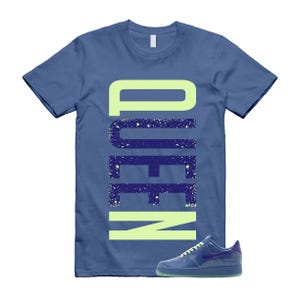 May include: Blue t-shirt with the word "QUEEN" in a vertical design. The word is in a light green font with a dark blue outline and white speckles. A blue sneaker with a purple accent is at the bottom right.