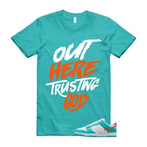 May include: A turquoise t-shirt with the words "OUT HERE TRUSTING GOD" in white and orange lettering. A pair of white, turquoise, and orange trainers are at the bottom of the image.