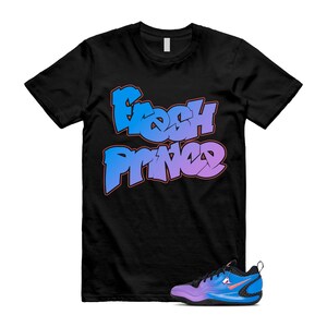 May include: Black t-shirt with the text "Fresh Prince" in blue and purple graffiti style. A blue and purple athletic shoe with an orange swoosh is next to the shirt.