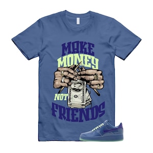May include: Blue t-shirt with the text "MAKE MONEY NOT FRIENDS" in purple and light green. The graphic shows hands knitting money with needles. A pair of blue sneakers with a purple swoosh are at the bottom.