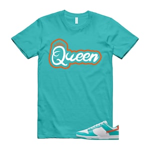 May include: A turquoise t-shirt featuring the word "Queen" in white script with an orange outline and a crown. A white, turquoise, and orange trainer is at the bottom of the image.