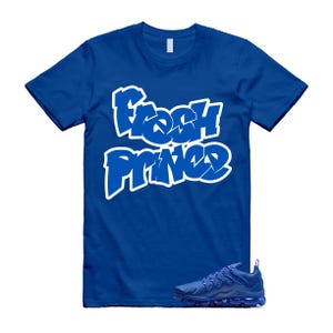 Pu&ograve; includere: T-shirt blu reale con la scritta "Fresh Prince" in bianco in stile graffiti. Un paio di scarpe da ginnastica blu abbinate &egrave; posizionato sotto. La maglietta ha maniche corte e girocollo.