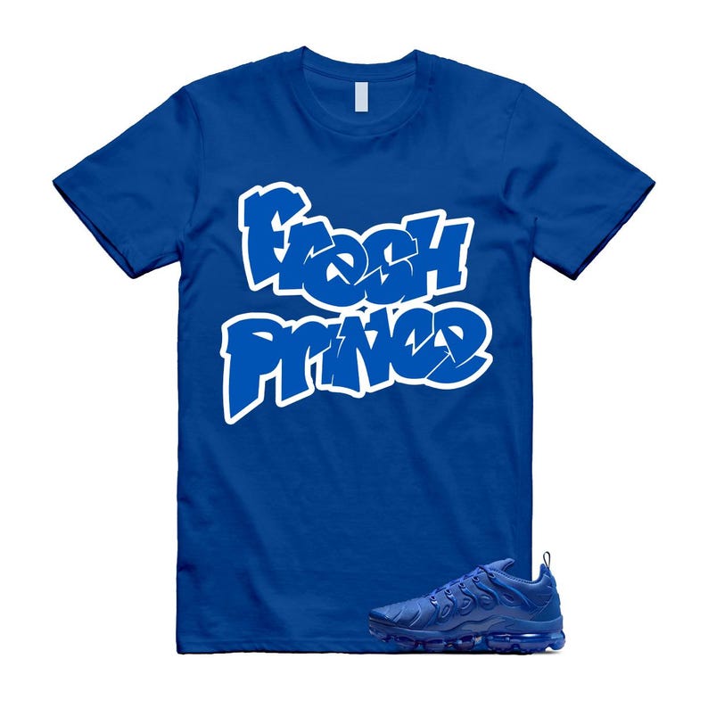 Pu&ograve; includere: T-shirt blu reale con la scritta "Fresh Prince" in bianco in stile graffiti. Un paio di scarpe da ginnastica blu abbinate &egrave; posizionato sotto. La maglietta ha maniche corte e girocollo.