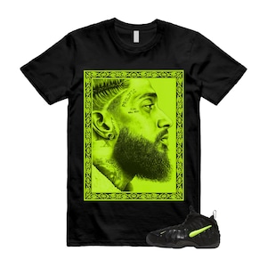May include: Black t-shirt featuring a neon green portrait of a man with the text "Prolific" and "The World's Mine". A pair of black and neon green sneakers are in the image. The t-shirt is a crew neck style.