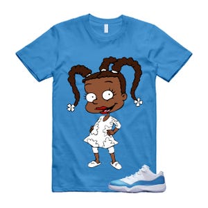 Puede incluir: Camiseta azul claro con un personaje de dibujos animados con un vestido blanco y zapatos blancos. El personaje tiene coletas marrones. Zapatillas blancas y azul claro en la parte inferior de la imagen.