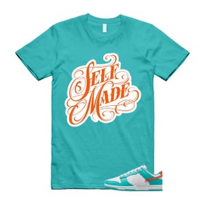 May include: A turquoise t-shirt with the words "SELF MADE" in orange script. A pair of white, turquoise, and orange trainers are at the bottom of the image. The shirt is a crew neck style.
