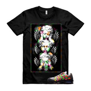 Op de afbeelding: Een zwart t-shirt met korte mouwen en een grafische print van drie verticaal gestapelde gevleugelde cherubijntjes, die elk hun ogen, oren of mond bedekken. Onder het shirt staat een sneaker met een veelkleurig geweven patroon en zwarte zool.