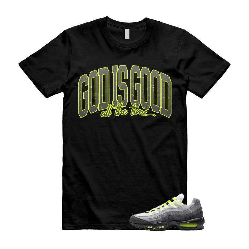 May include: Black t-shirt with the text "GOD IS GOOD all the time" in a yellow and gray design. A pair of gray, black, and yellow sneakers are in the lower right corner. The sneakers have a white sole and a black outsole.